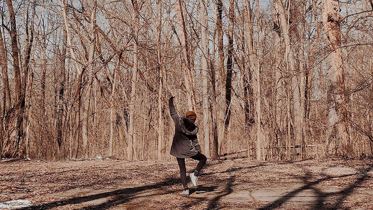 Girl dancing on wooded trail